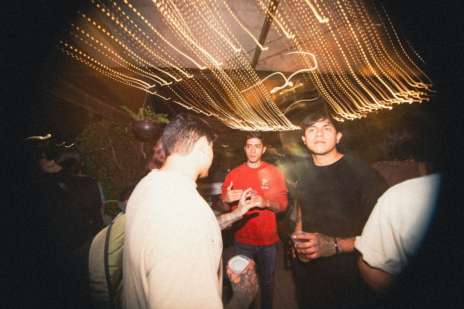 People dancing under string lights at night
